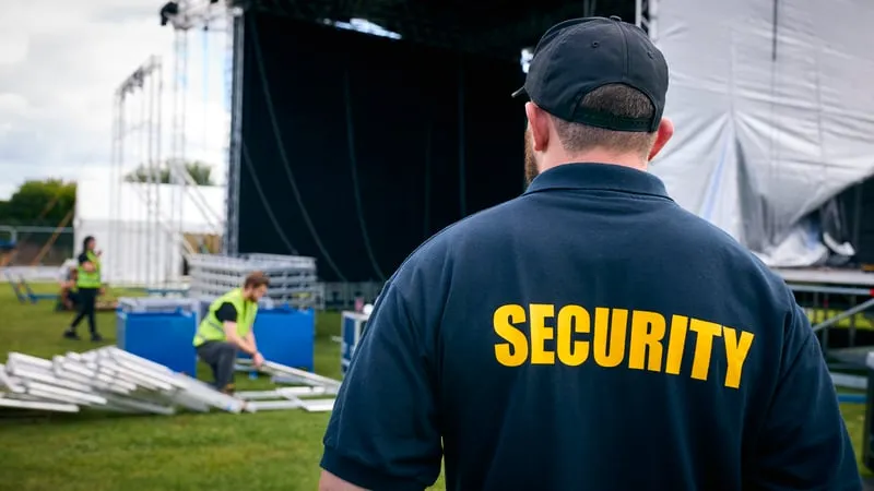 Bewakingsagent van KG Security houdt toezicht tijdens de opbouw van een evenement
